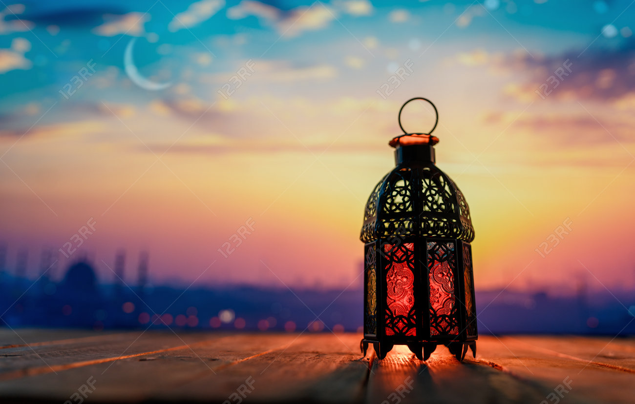 228479582-ornamental-arabic-lantern-with-burning-candle-glowing-at-night-background-festive-greeting-card